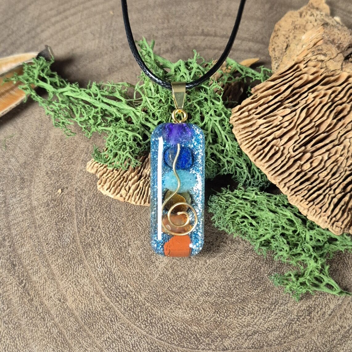 orgonite amulet lang diverse kleuren blauwe achtergrond